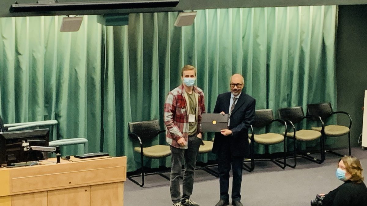 Two people stand on stage.