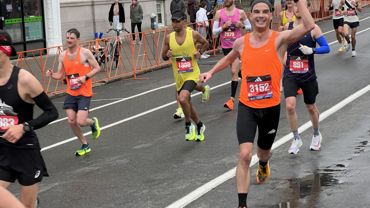 A runner raises his arm in celebration.