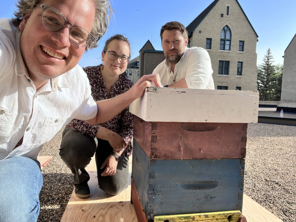 Three people and a beehive