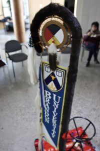 Close-up view of an Eagle Staff, showing off the painted medicine wheel and otter fur.