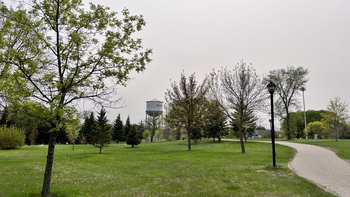 Pathway stretches through a park, with a large civic water tower in the background.