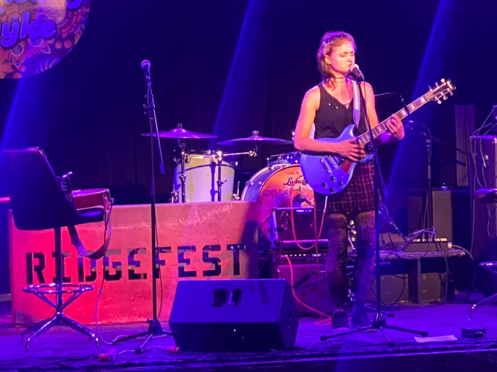 A woman sings and plays guitar.
