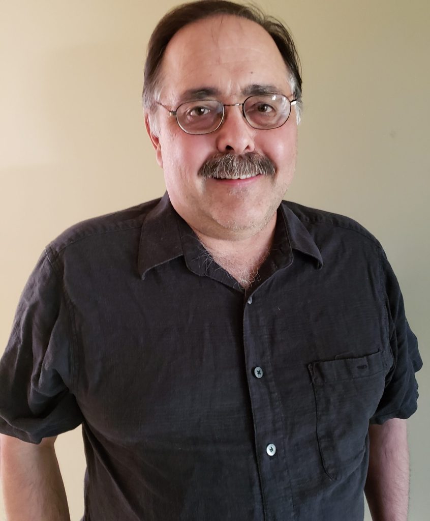 Smiling man with glasses and a moustaches.