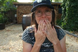 A woman holds her hands over her mouth