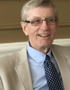A man in glasses and a suit.