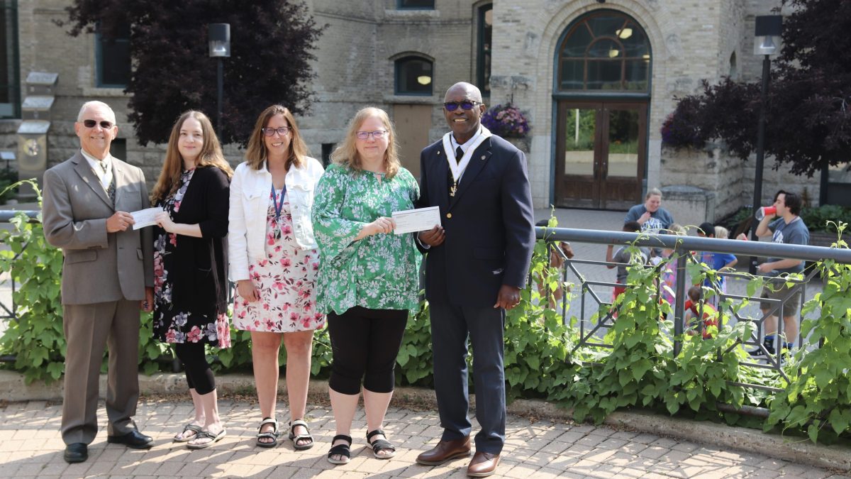 Five people stand in a courtyard