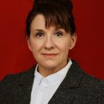 Head and shoulders hot of a woman in front of a red background