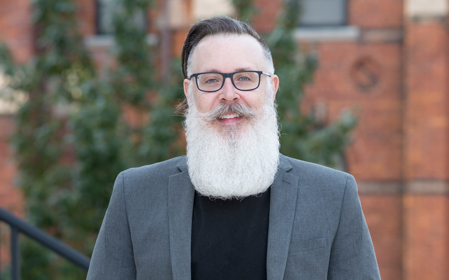 A man in glasses and a large white beard.