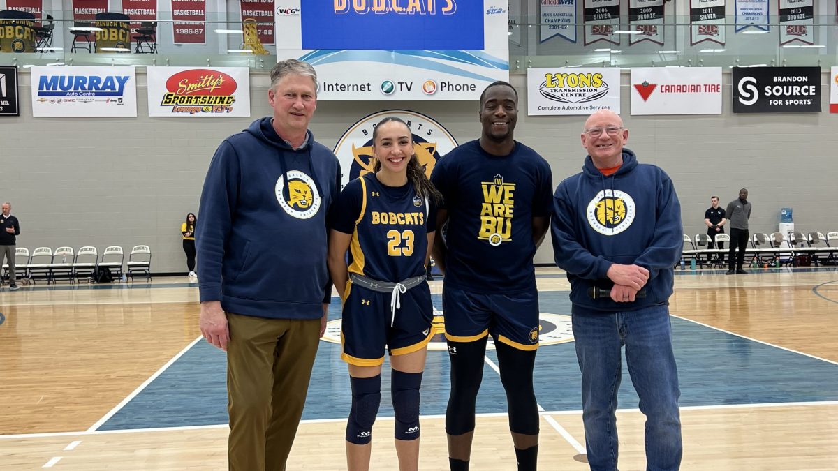 Four pepole stand in a gym.