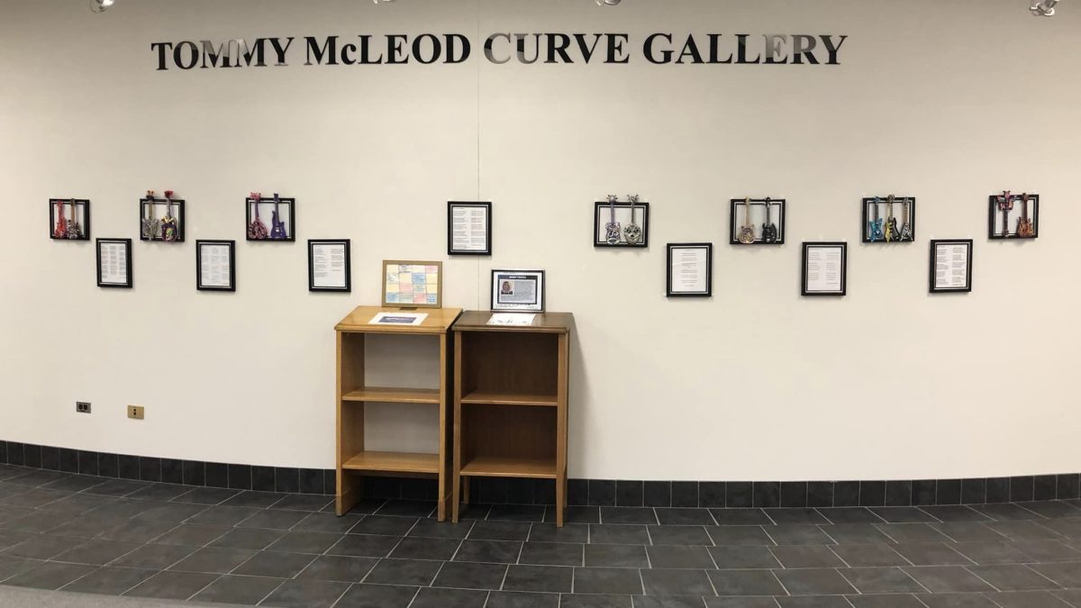 A display of brightly coloured guitars and poetry on a gallery wall.