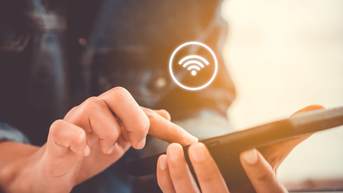A person's hand is using smartphone with wifi icon