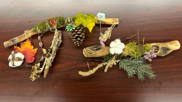 Moss, leaves and pine cones tied onto branches