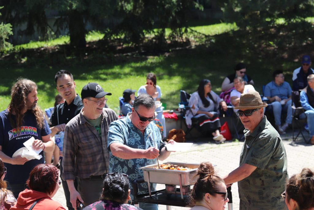 A group of men serve food from a cart