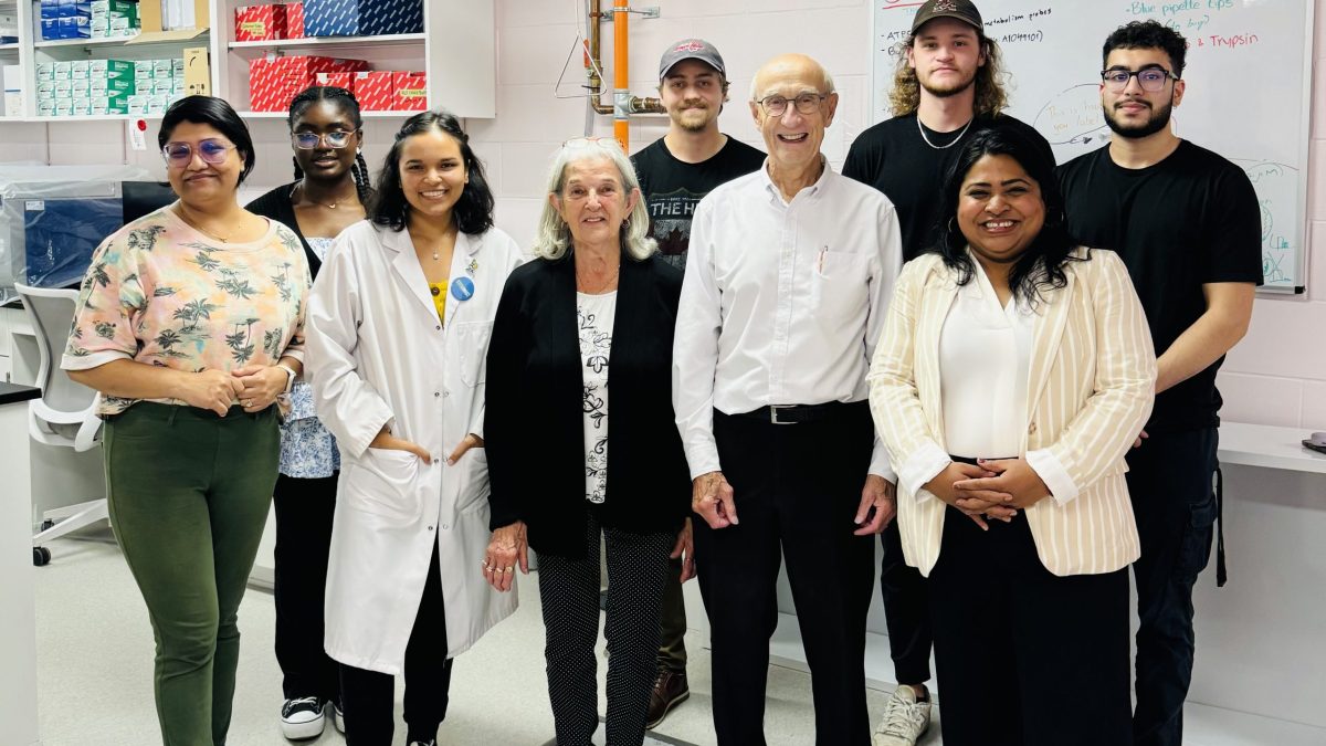 A large group of people stand in a laboratory