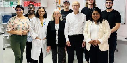 A large group of people stand in a laboratory