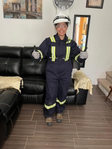 A woman gives a double thumbs up sign while in high-viz safety garb.