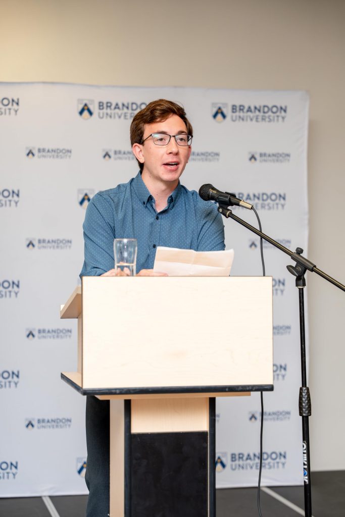 A young man speaks at a podium.
