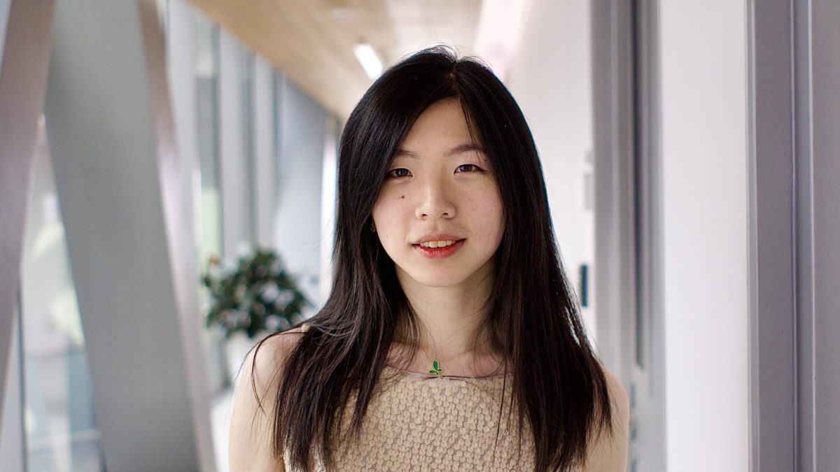 A woman poses in a long hallway
