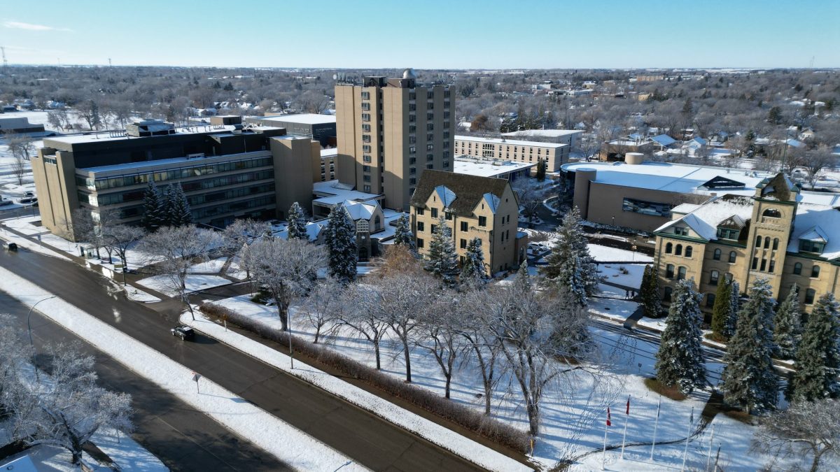 A variety of buildings are shown in an aerial view on a snowy day.