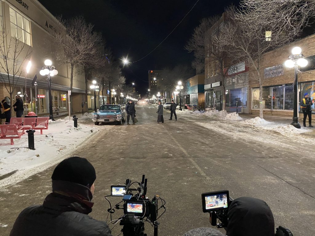 Cameras film a scene at night on a snowy street