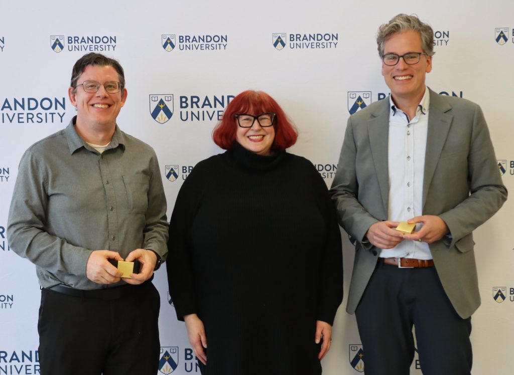 A women poses with a man to her left and a man to her right