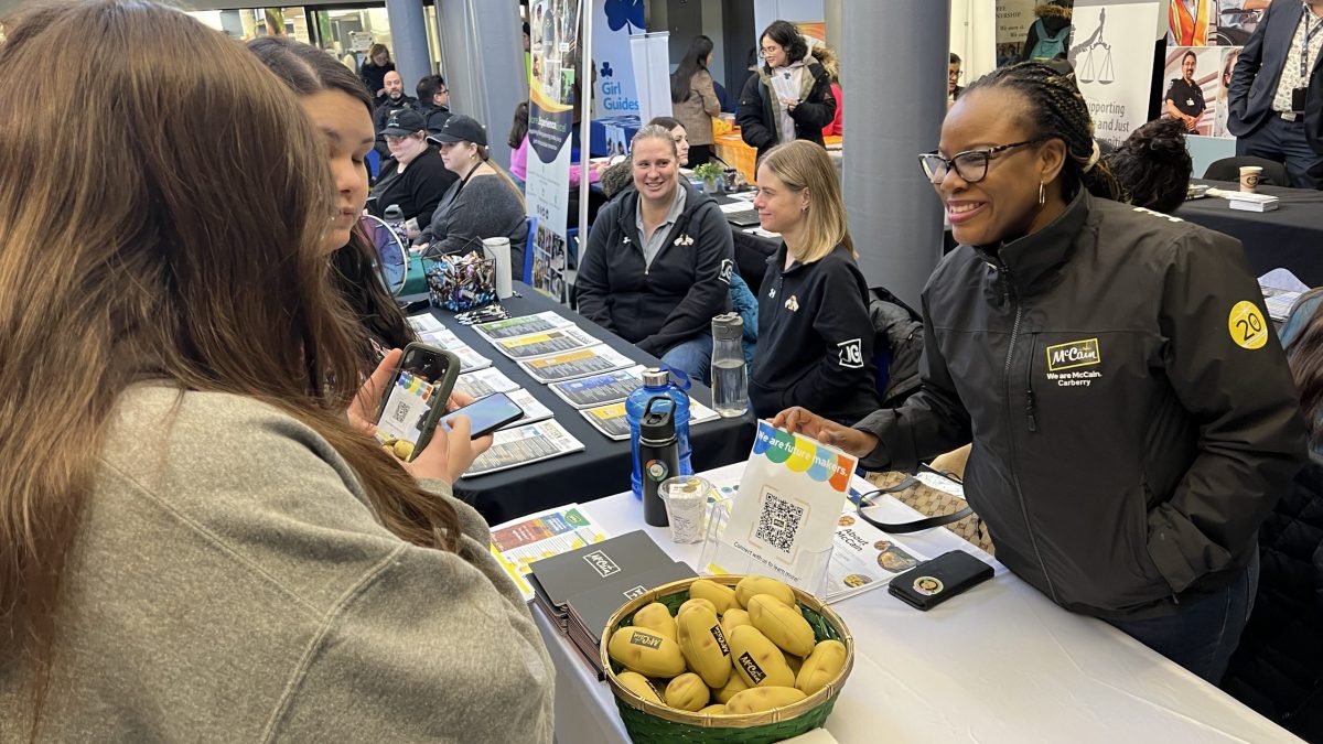 Students connect with employers at a kiosk.