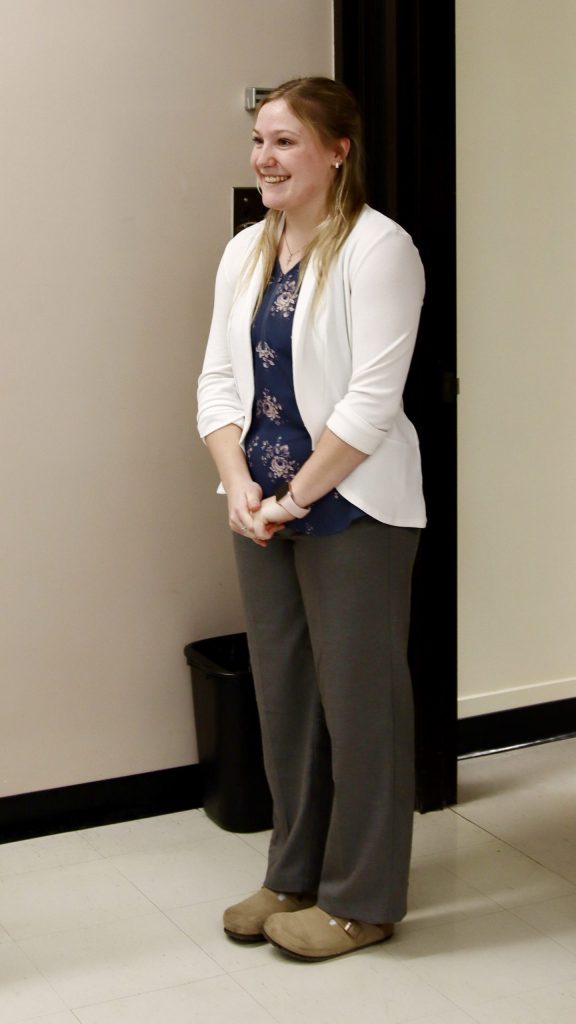 A woman beams while trying on a new outfit
