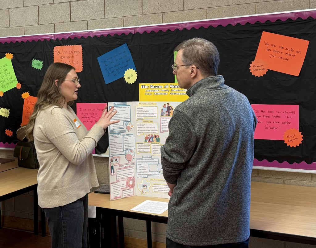 A woman motions with her hand as she speaks to a man.
