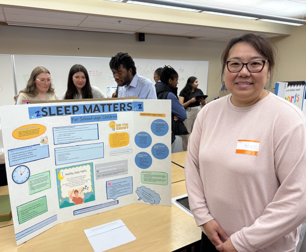 A woman stand next to a display titled Sleep Matters.