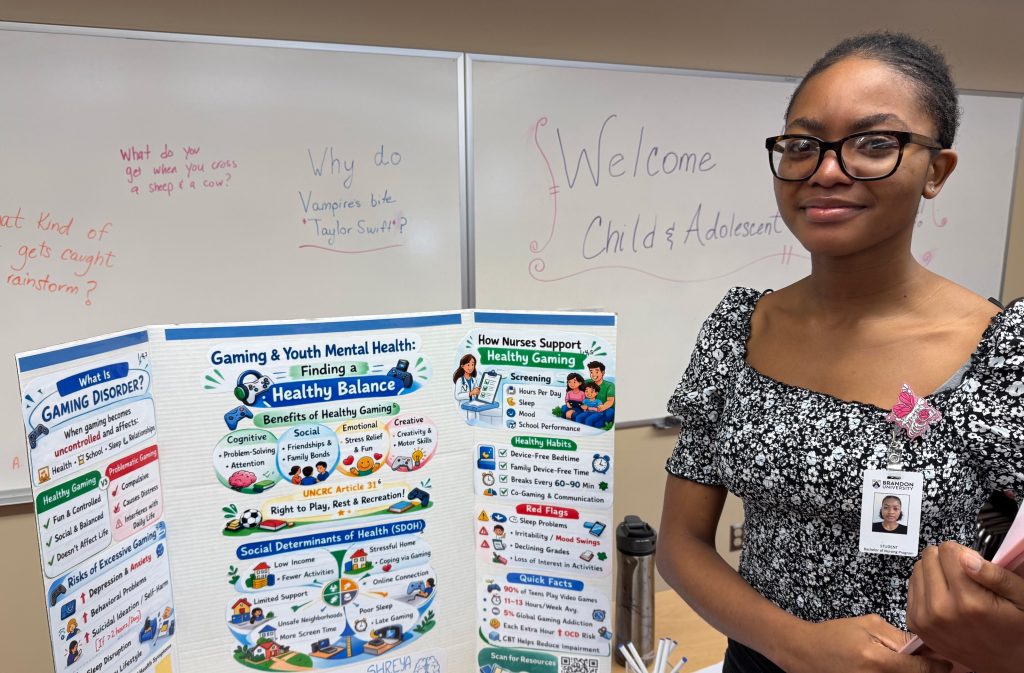 A woman stands next to a display about gaming and youth mental health.
