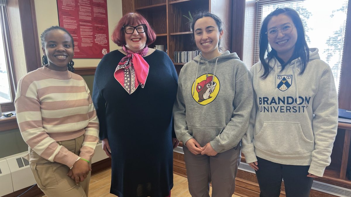 Four women stand in an office