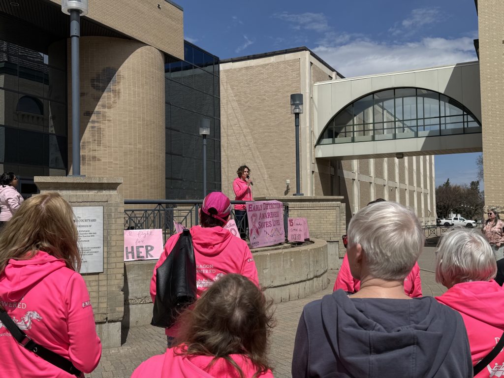A woman speaks to a crowd of people.