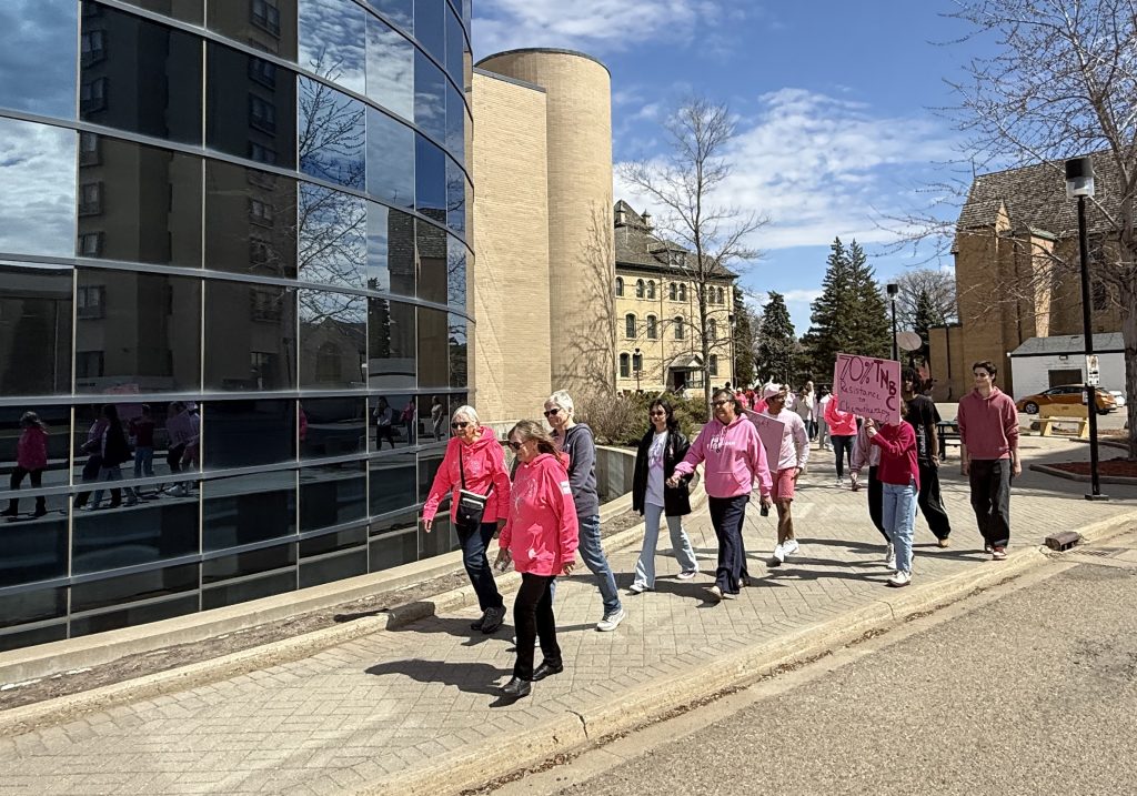 A group of people walk past reflective windows