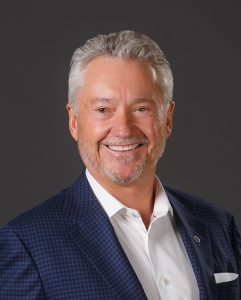Smiling man with short-cropped gray hair and goatee.