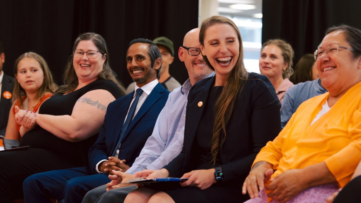 Several people laugh while seated.