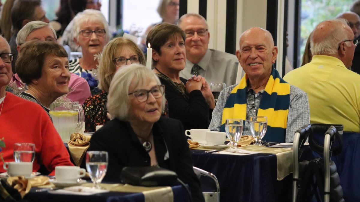 A group of alumni, including one in a Brandon University scarf, at the BU Homecoming Awards Dinner in 2025.