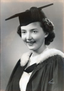 Vintage black and white portrait of a young woman in graduation garb.