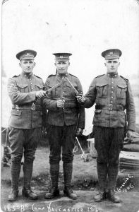 Vintage black and white photo of three soldiers i uniform touching bayonets together.