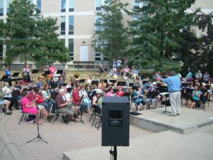 A large band plays outside in an amphitheatre