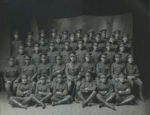 A group of military men pose for a platoon portrait un WW1 dress uniforms.