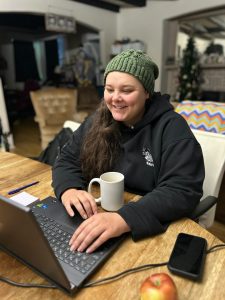 Young woman works at a laptop at home.