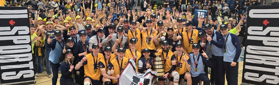 A volleyball team poses with a trophy.