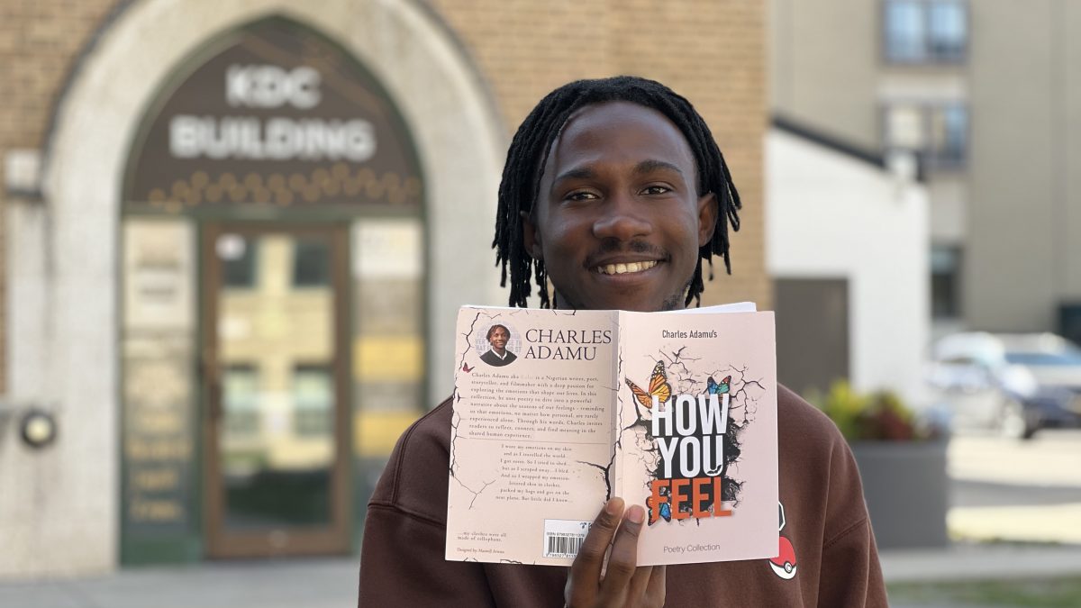 A man holds up a book in front of his face.