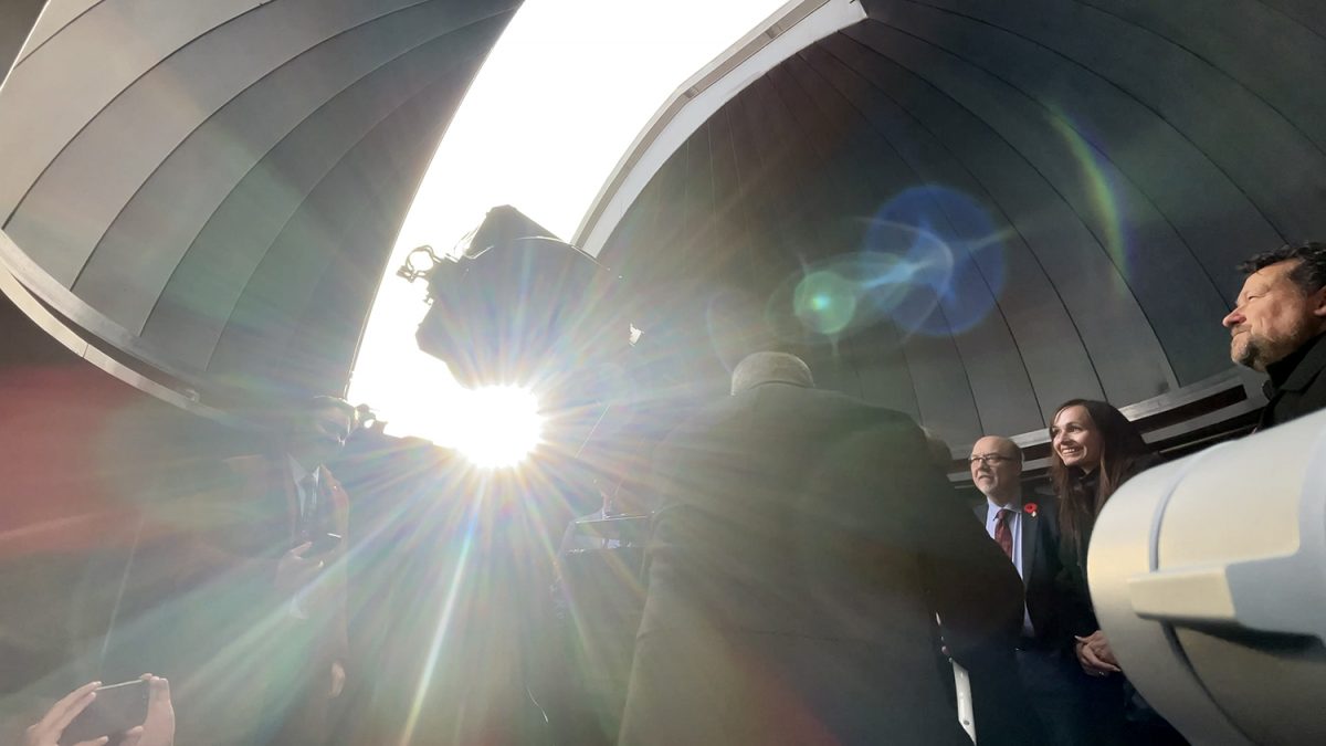 A group of people look through a telescope in the Gulliver Astronomical Observatory.