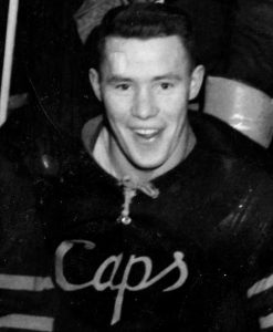 A man wearing a Caps hockey jersey smiles
