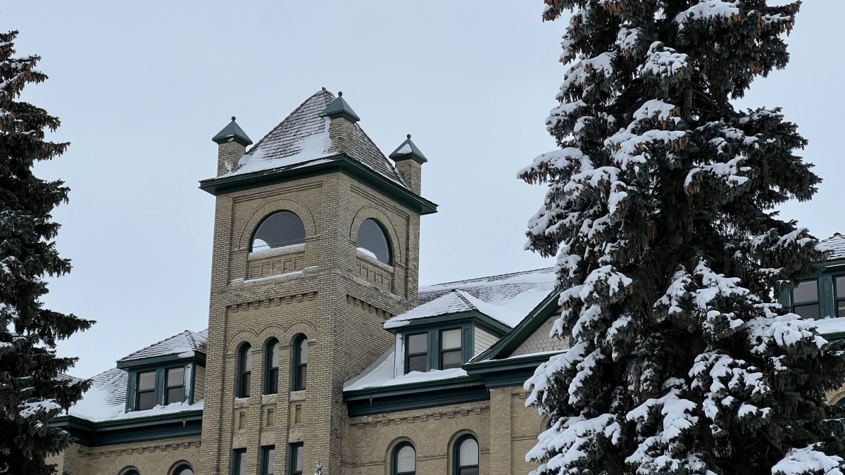 A brick tower is shown with snow trees in front