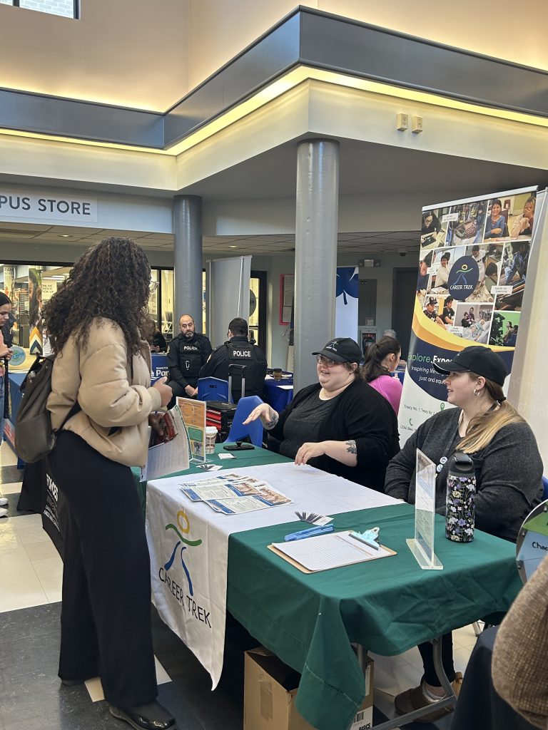 Students connect with employers at a kiosk.