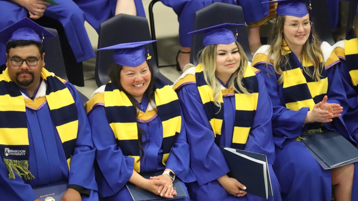 A row of graduates sit
