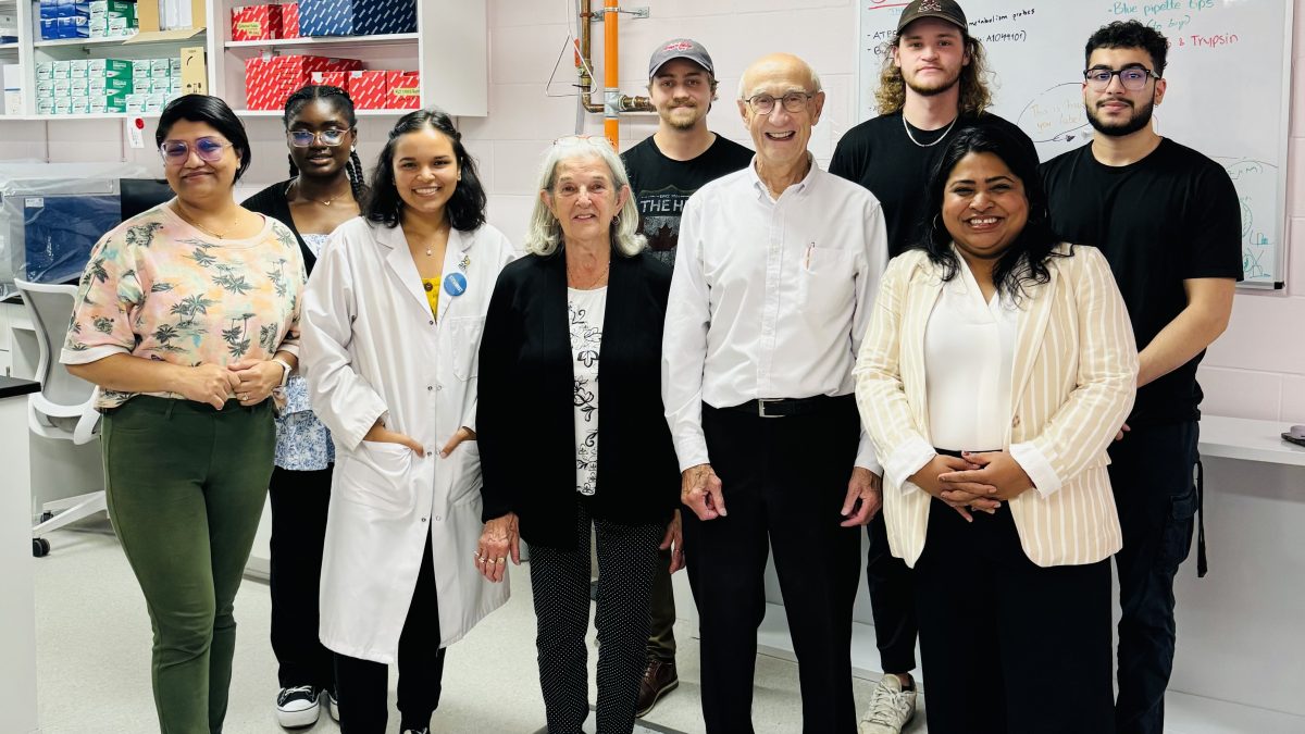 A large group of people stand in a laboratory