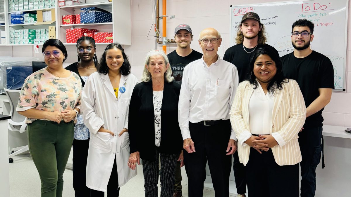 A large group of people stand in a laboratory